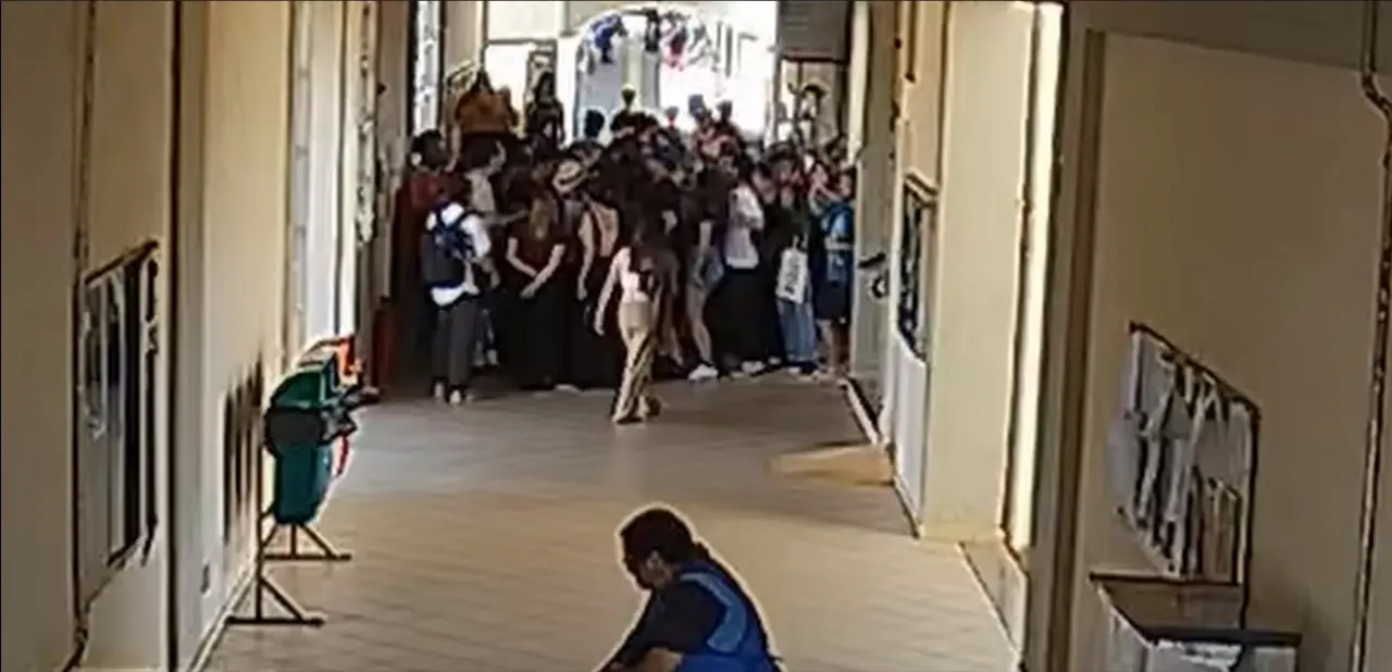 Câmera de segurança da universidade registrou a agressão; O professor está com o chapéu, cercado por estudantes